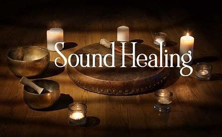 Sound Healing Drum on a wooden floor surrounded by candles and singing bowls