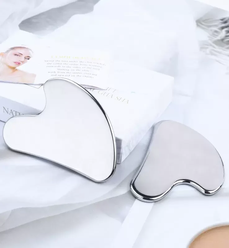 two silver Gua Sha tools